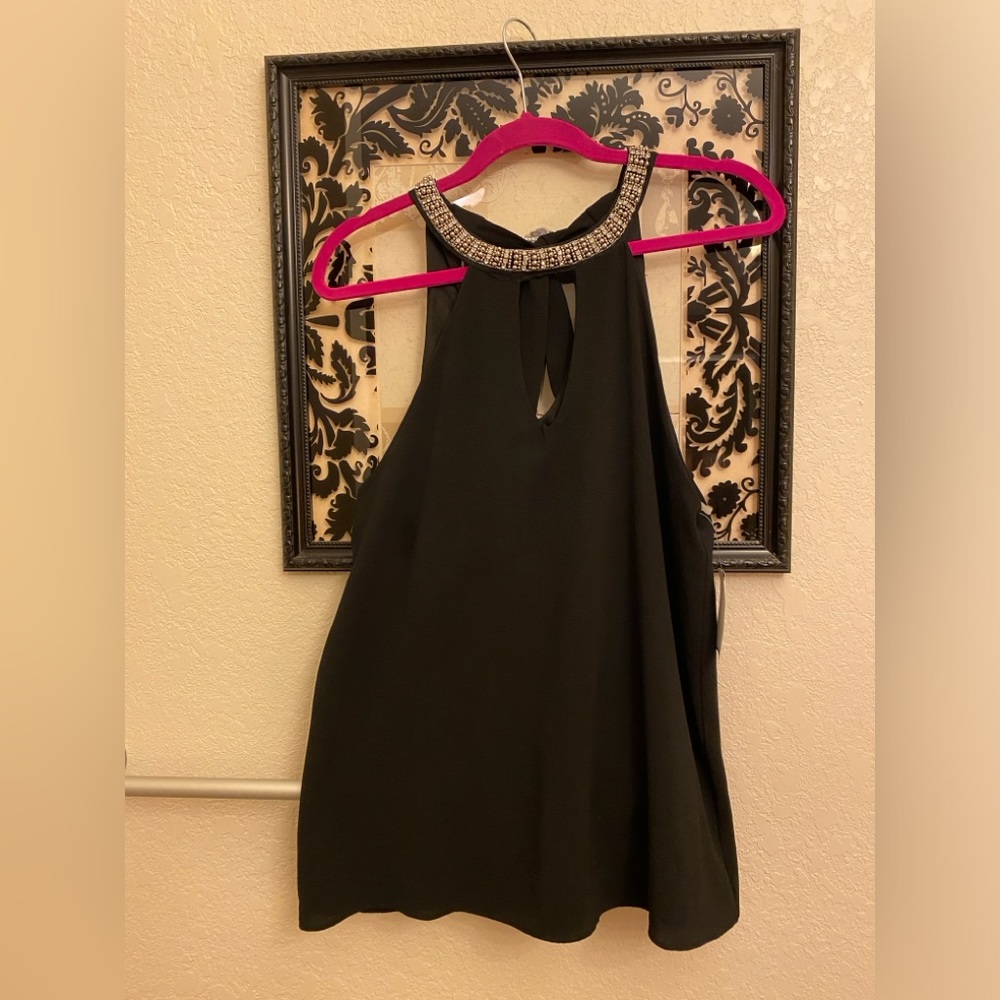 Black halter top with embellishments around necklace. Tie keyhole back. Sz Med